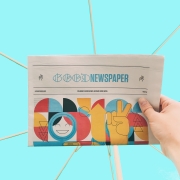 image of hand holding a newspaper with the heading 