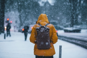 person wearing a winter coat and backpack