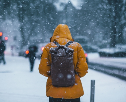 person wearing a winter coat and backpack