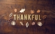 the word thankful on wooden background; Sharing Gratitude