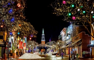 image of traditional small town main street lit with Christmas lights with church at the end of the street - connection