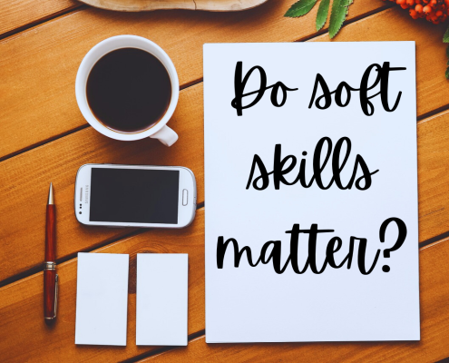 desktop showing aerial view of full coffee cup, phone, notepad and pen, with white paper that has "Do soft skills matter?" written on it