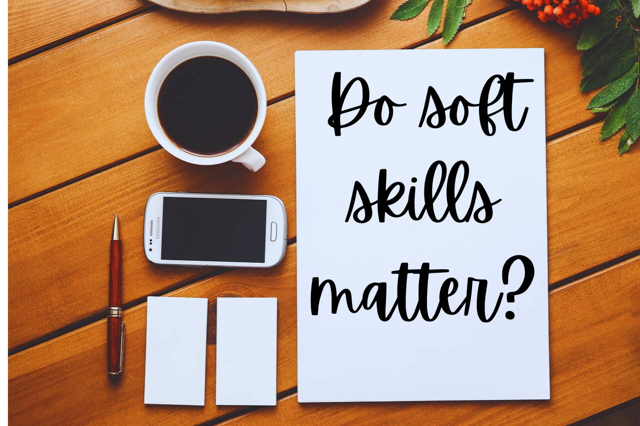 desktop showing aerial view of full coffee cup, phone, notepad and pen, with white paper that has "Do soft skills matter?" written on it