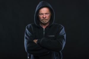image of man in hoodie frowning, with arms crossed, non-verbal communication