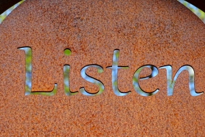 rusted sign with the word listen cut out of it