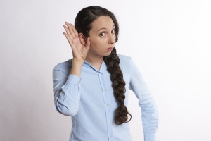 image of a woman leaning forward with her hand to her ear: listening; soft skills matter: communication