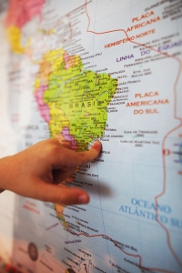 a hand pointing to Brazil on a map