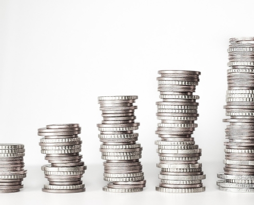 stacks of silver coins on white background set up like a graph; key energy indicators