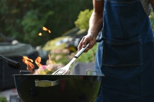 image of a person standing by a grill with a spatula; Memorial Day - what does it mean?