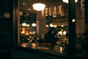 image through a bar window at night, with word RELAX on window