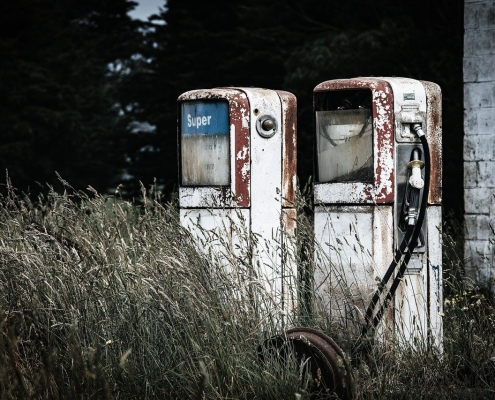 rusted fuel pumps with long grass