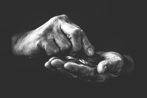 black and white image of hands holding a few coins, poverty; Labor Day - Recognizing Workers