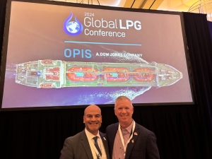 JD Buss and another presenter in front of OPIS promo screen at LPG conference