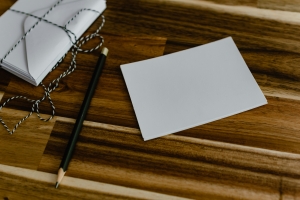 blank notecard on a brown surface, next to a pencil; sharing gratitude