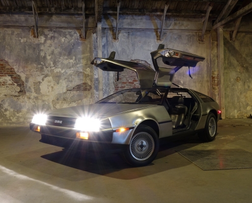 DeLorean car with doors up and lights on in front of gray wall; What will the new year bring, market predictions for 2025