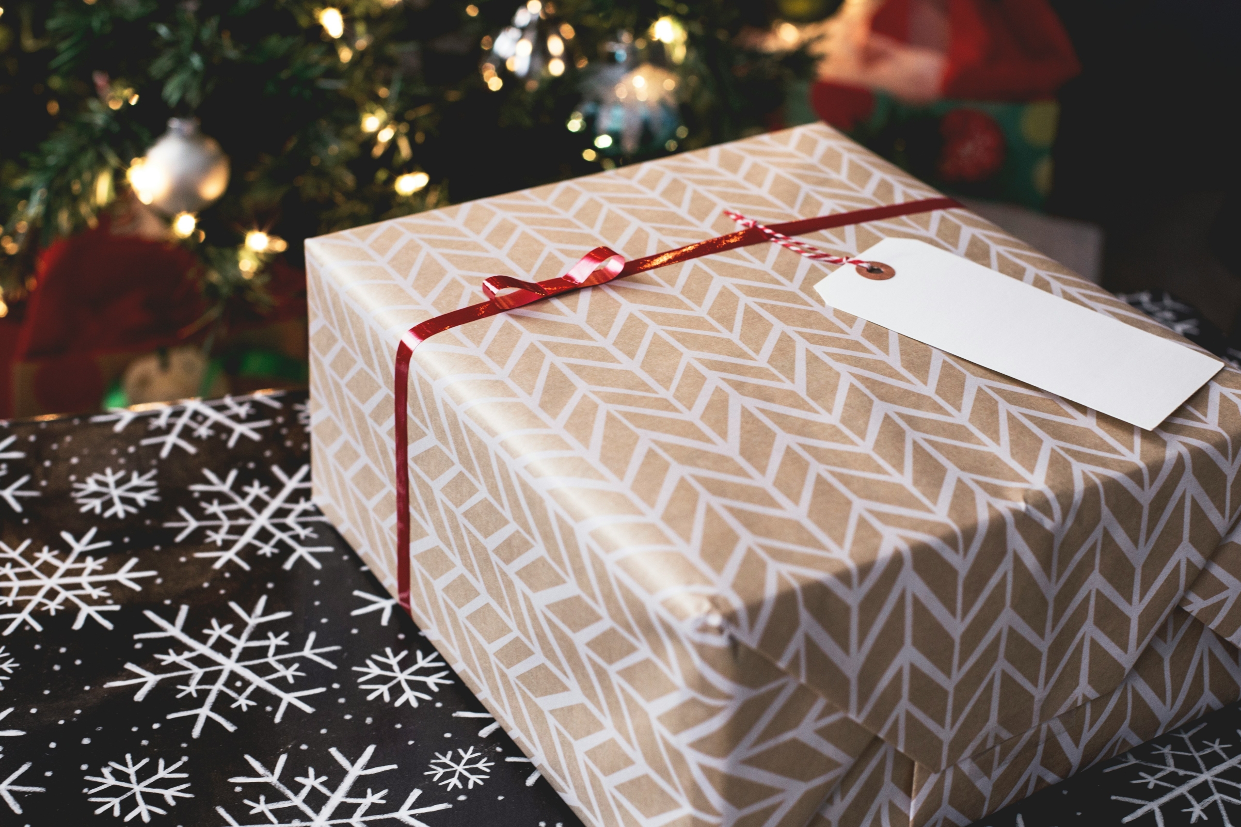 closeup of a wrapped Christmas gift under a tree; time with family at Christmas