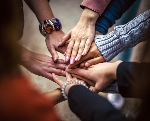 image of hands reaching toward each other in a circle; Hospitality is a team sport