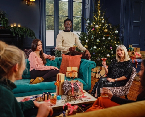 people relaxing in a living room with Christmas tree in the background; time with family at Christmas