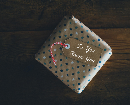 square package wrapped in brown paper with small blue stars and a tag that reads to: you, from: you; unreasonable hospitality - a gift you give yourself