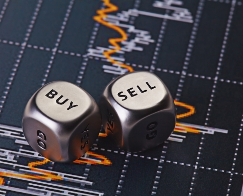 silver dice with words "buy" and "sell" on them on a background of financial trade info; Hedging 301 - Options - what are they?